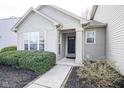 Close-up of a front door with a welcoming entrance and meticulous landscaping at 10047 Perlita Pl, Fishers, IN 46038