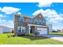 Attractive two-story brick home with a green lawn and a two-car garage on a sunny day at 10465 Long Branch Dr, Brownsburg, IN 46112
