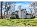 View of the home's backyard featuring a lawn, mature trees, screened porch, and a neutral-toned exterior at 11249 Tall Trees Dr, Fishers, IN 46038