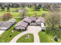 Aerial view of a charming single-story home with an expansive lawn and scenic golf course views at 1153 Diablo Rd, Greenwood, IN 46143