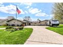 Charming single-story home with manicured lawn, circular driveway, and American flag at 1153 Diablo Rd, Greenwood, IN 46143