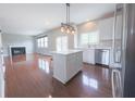 Bright, open kitchen with white cabinets, stainless steel appliances and an island extending to the living room at 12332 Cobblefield Ct, Fishers, IN 46037