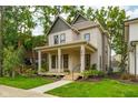Inviting two-story home with a covered porch and well-manicured lawn at 1818 Central Ave, Indianapolis, IN 46202