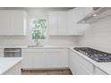 Well-lit kitchen featuring stainless steel appliances, white cabinetry, subway tile backsplash and wood floors at 18944 Seaforth Way, Westfield, IN 46074