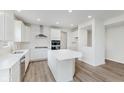 Bright kitchen featuring white cabinets, stainless steel appliances, island and wood flooring at 18944 Seaforth Way, Westfield, IN 46074