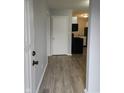 Inviting entryway with wood-look flooring that leads to a kitchen with black appliances at 1931 Brentwood Dr, Anderson, IN 46011