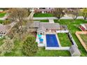 Aerial view of a home with a pool, a patio area with seating, and a large grassy yard at 2001 Winchester Dr, Indianapolis, IN 46227