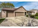 Charming brick home featuring a two-car garage, covered porch, and well-maintained lawn at 2034 Milburn Dr, Brownsburg, IN 46112
