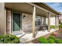 Inviting covered front porch with rocking chairs, decorative plants and stylish front door at 2034 Milburn Dr, Brownsburg, IN 46112