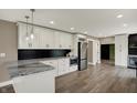 Modern kitchen with white cabinets, granite countertops, stainless steel appliances, and hardwood floors at 2103 Postmaster Ln, Greenfield, IN 46140