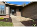 Inviting front entrance featuring a covered porch and freshly landscaped garden beds at 2206 Tansel Crossing Cir, Indianapolis, IN 46234
