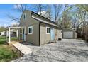 View of renovated home featuring a gravel driveway and detached garage at 2249 N Centennial St, Indianapolis, IN 46222