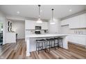 Bright, all-white kitchen featuring a center island with seating, stainless steel appliances, and wood-look floors at 2741 Penn Ave, Plainfield, IN 46168