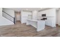 Modern kitchen with white cabinets, a center island, stainless steel appliances, and hardwood floors at 2741 Penn Ave, Plainfield, IN 46168