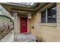 The front entrance to the home features a red door, brick exterior, and porch at 5017 E 14Th St, Indianapolis, IN 46201