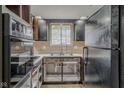Kitchen under construction with black appliances, double sinks, and vintage tile backsplash at 5017 E 14Th St, Indianapolis, IN 46201