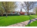 A well-maintained brick home with a lush green lawn and mature trees in a quiet neighborhood at 5124 Mccray St, Indianapolis, IN 46224