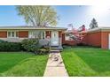 A well-kept brick home featuring a lush lawn, flowering bushes and a welcoming front entrance at 5124 Mccray St, Indianapolis, IN 46224