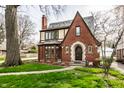Charming brick Tudor home with a manicured lawn and walkway to the front door at 5157 N New Jersey St, Indianapolis, IN 46205