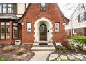 Close-up of a brick Tudor-style home, showcasing the arched doorway and front entrance at 5157 N New Jersey St, Indianapolis, IN 46205