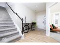 Bright entryway featuring hardwood floors, staircase, and decorative bicycle accent, creating a welcoming first impression at 5300 Veranda Dr, Noblesville, IN 46062