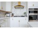 Close-up view of the kitchen with modern stainless-steel appliances, including double ovens and a gas cooktop at 5300 Veranda Dr, Noblesville, IN 46062