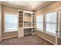 Bright office space featuring built-in shelving and desk, carpeted floors, and natural light from two windows at 5493 W Woodhaven Dr, McCordsville, IN 46055
