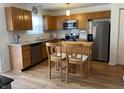 Bright kitchen featuring stainless steel appliances, white subway tile, wood cabinets, and breakfast bar at 5663 Rains Ln, Indianapolis, IN 46254