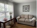 Cozy living room with hardwood floors, neutral paint, comfortable seating, and large window at 5663 Rains Ln, Indianapolis, IN 46254