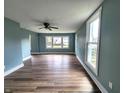 Open concept living room features many windows, a ceiling fan, new laminate floors, and fresh paint at 601 Duane St, Franklin, IN 46131