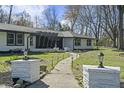 A well-lit pathway leads to this stylish home with a beautifully landscaped yard and mature trees at 6025 Crows Nest Dr, Indianapolis, IN 46228