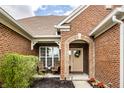 Inviting front porch with seating, a beautifully decorated door, and red brick at 6049 Royal Gate Pl, Indianapolis, IN 46237