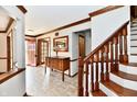 Bright foyer featuring tile floors, wood trim, a staircase, and a view to the front entrance at 611 Mill Farm Rd, Noblesville, IN 46062
