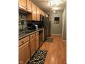 Efficient kitchen layout, featuring stainless steel appliances and natural wood cabinets at 6525 Emerald Hill Ct # 208, Indianapolis, IN 46237
