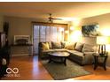 Cozy living room featuring an L-shaped couch, hardwood floors, and a ceiling fan at 6525 Emerald Hill Ct # 208, Indianapolis, IN 46237