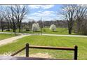 Scenic view from the porch showcasing a lush green lawn and mature trees across the street at 7440 S 250 W, Pendleton, IN 46064
