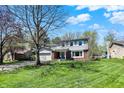 Charming two-story home featuring a blue front door, attached garage and manicured landscaping at 7728 Mallard Way, Indianapolis, IN 46256