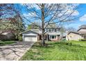 Charming two-story home featuring a blue front door, attached garage and manicured landscaping at 7728 Mallard Way, Indianapolis, IN 46256