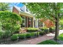 Beautiful brick home with manicured front lawn, black fence, brick walkway, and mature landscaping at 8089 Lynch Ln, Indianapolis, IN 46250