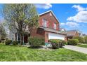 Lovely brick two-story home with red shutters, a two-car garage and a well-kept lawn with landscaping at 8116 Barksdale Way, Indianapolis, IN 46216