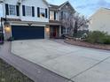 Traditional two-story home with dark blue garage door, brick walkway, and blooming tree in the front yard at 82 Pin Oak Ct, Whiteland, IN 46184