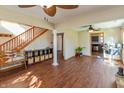 Spacious living room with wood floors, wood stairs, ceiling fans, and view into kitchen at 82 Pin Oak Ct, Whiteland, IN 46184
