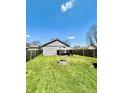Spacious backyard featuring a fire pit and a well-manicured lawn surrounded by a wooden fence at 1117 Hendricks Ave, Shelbyville, IN 46176