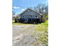 Exterior view of home featuring gray siding, black deck, and gravel driveway at 1117 Hendricks Ave, Shelbyville, IN 46176
