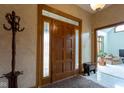 Warm and inviting foyer with a wooden front door, patterned rug, and coat rack at 11203 Westminster Way, Carmel, IN 46033