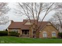 Inviting stone home with a manicured lawn, appealing roof, and a cozy, classic design at 11203 Westminster Way, Carmel, IN 46033