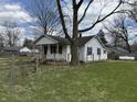 A view of the home's backyard, partially fenced with grass and large trees at 130 Hiawatha Dr, Noblesville, IN 46062