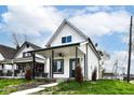 This home boasts a covered porch, black trim, and newly landscaped yard at 1814 New St, Indianapolis, IN 46203