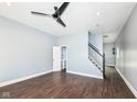Open living room offers wood floors, fresh paint, updated lighting, and convenient access to the stairs at 1814 New St, Indianapolis, IN 46203