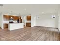Open-concept living area featuring wood floors, natural light, and a seamless flow into the kitchen at 19123 River Jordan Pass, Westfield, IN 46074